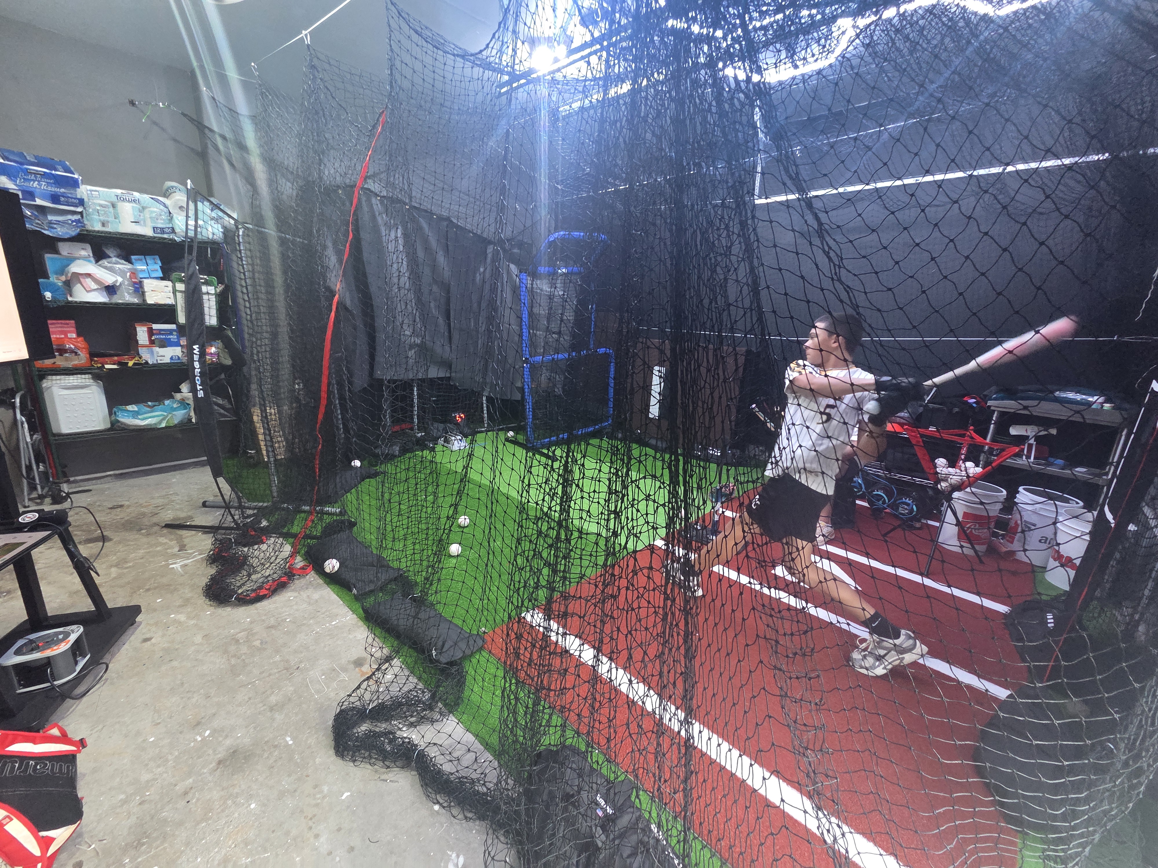 An athlete mid-swing inside the Garage Lab cage in Stafford.